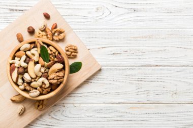 mixed nuts in bowl. Mix of various nuts on colored background. pistachios, cashews, walnuts, hazelnuts, peanuts and brazil nuts.