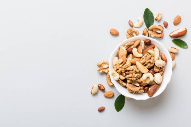 mixed nuts in bowl. Mix of various nuts on colored background. pistachios, cashews, walnuts, hazelnuts, peanuts and brazil nuts.
