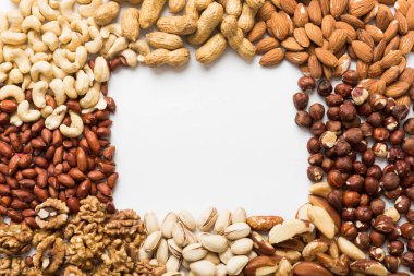 different nuts frame background. Close up, top view, flat lay with vopy space. Walnut, pistachios, almonds, hazelnuts and cashews.