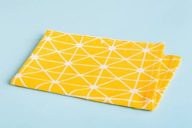 top view with yellow empty kitchen napkin isolated on table background. Folded cloth for mockup with copy space, Flat lay. Minimal style.