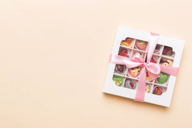 Box with sweet chocolate candies on color background, Various candy sweets. Valentines day gift box. Top view flat lay with copy space.