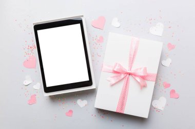 Gift box of open tablet for the holidays with a bow top view.