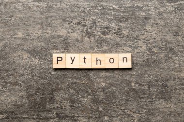 Tahta blokta piton kelimesi yazılı. Python metni tablo üzerinde, konsept.
