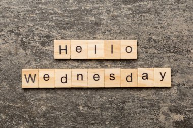 Merhaba çarşamba günü tahta blokta yazan kelime. Merhaba çarşamba günü çimento masasının üzerindeki yazı..