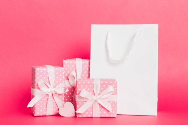 Shopping bag with gift box on colored background perspecrive view. Space for text holiday concept.