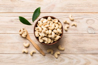cashew nuts in wooden bowl on table background. top view. Space for text. Healthy food clipart
