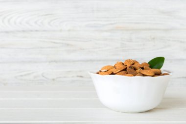 Fresh healthy Almond in bowl on colored table background. Top view.