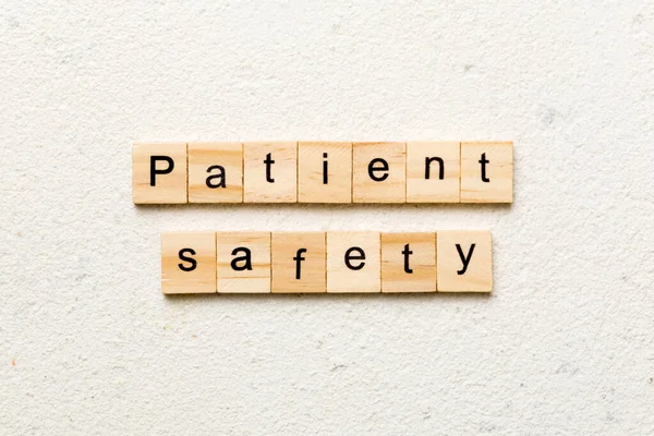 Patient Safety word written on wood block. Patient Safety text on cement table for your desing, concept.