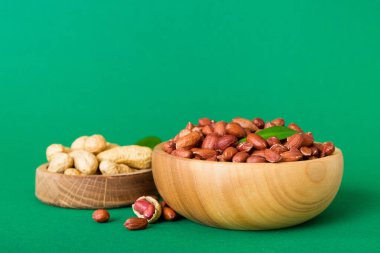 Fresh healthy peanuts in bowl on colored table background. Top view Healthy eating bertholletia concept. Super foods.