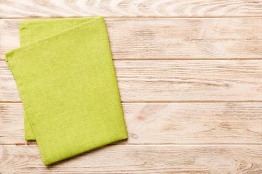 top view with green kitchen napkin isolated on table background. Folded cloth for mockup with copy space, Flat lay. Minimal style.
