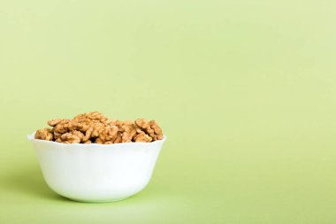Fresh healthy walnuts in bowl on colored table background. Top view Healthy eating bertholletia concept. Super foods.