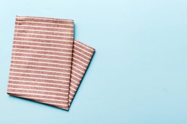 top view with red empty kitchen napkin isolated on table background. Folded cloth for mockup with copy space, Flat lay. Minimal style.
