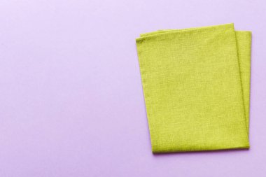 top view with green kitchen napkin isolated on table background. Folded cloth for mockup with copy space, Flat lay. Minimal style.