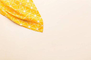 top view with yellow empty kitchen napkin isolated on table background. Folded cloth for mockup with copy space, Flat lay. Minimal style.