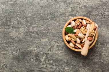 mixed nuts in bowl. Mix of various nuts on colored background. pistachios, cashews, walnuts, hazelnuts, peanuts and brazil nuts.