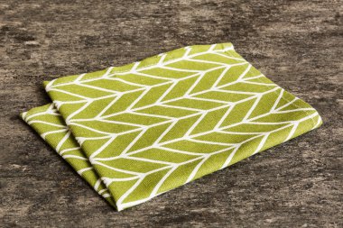 top view with green kitchen napkin isolated on table background. Folded cloth for mockup with copy space, Flat lay. Minimal style.