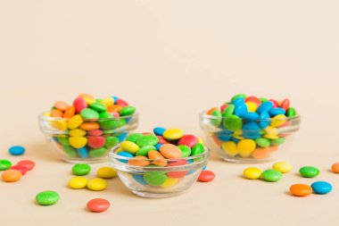 Renkli arka planda bir kasede çok renkli şekerler. Doğum günü ve tatil konsepti. Kopyalama alanı olan üst görünüm.