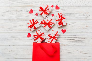 Gift boxes pop out from paper bag top view on colored background. bag packing handmade boxes fall out Concept of holidays, shopping, sale, discounts. Top view, flat lay.