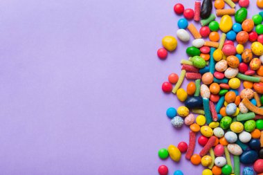 Renkli arka planda karışık renkli şeker koleksiyonu. Düz yerde, üst tarafta. Renkli çikolata kaplı şeker çerçevesi.