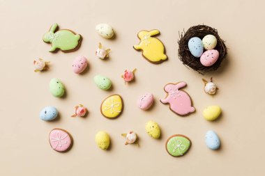 Colorful easter eggs in nest on table background with copy space top view.