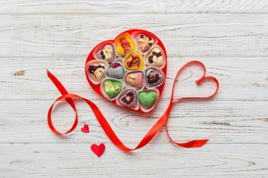 Valentine day composition: sweet candy, with gift boxes with bow and red felt hearts, photo template, background. Top View with copy space.