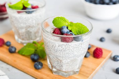 Sağlıklı kahvaltı ya da sabah chia tohumlu vanilyalı puding ahududu ve böğürtlen, vejetaryen gıda, diyet ve sağlık konsepti. Ahududu ve yabanmersinli Chia pudingi..