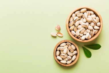 Renkli masa arkasında kasede taze ve sağlıklı Pistachio tabağı. Üst Manzara. Sağlıklı beslenme konsepti. Süper Yiyecekler.