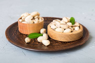 Fresh healthy Pistachios in bowl on colored table background. Top view. Healthy eating concept. Super foods.