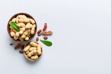 Fresh healthy peanuts in bowl on colored table background. Top view Healthy eating bertholletia concept. Super foods.