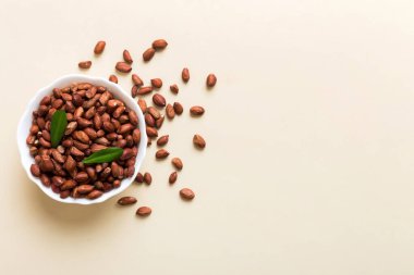 Fresh healthy peanuts in bowl on colored table background. Top view Healthy eating bertholletia concept. Super foods.