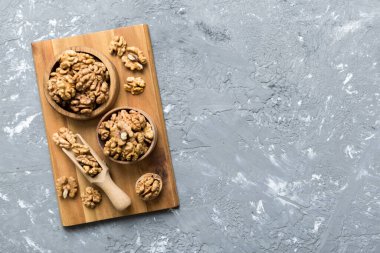 Fresh healthy walnuts in bowl on colored table background. Top view Healthy eating bertholletia concept. Super foods.