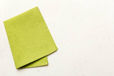 top view with green kitchen napkin isolated on table background. Folded cloth for mockup with copy space, Flat lay. Minimal style.