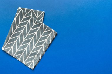 top view with blue kitchen napkin isolated on table background. Folded cloth for mockup with copy space, Flat lay. Minimal style.