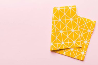 top view with yellow empty kitchen napkin isolated on table background. Folded cloth for mockup with copy space, Flat lay. Minimal style.