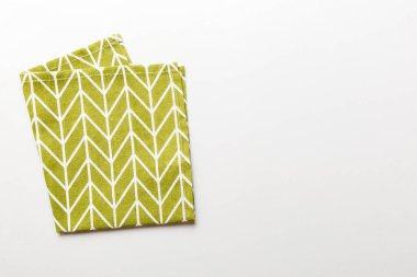 top view with green kitchen napkin isolated on table background. Folded cloth for mockup with copy space, Flat lay. Minimal style.