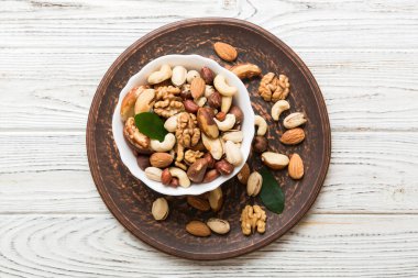 mixed nuts in bowl. Mix of various nuts on colored background. pistachios, cashews, walnuts, hazelnuts, peanuts and brazil nuts.