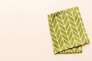 top view with green kitchen napkin isolated on table background. Folded cloth for mockup with copy space, Flat lay. Minimal style.