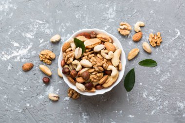 mixed nuts in bowl. Mix of various nuts on colored background. pistachios, cashews, walnuts, hazelnuts, peanuts and brazil nuts.