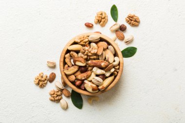 mixed nuts in bowl. Mix of various nuts on colored background. pistachios, cashews, walnuts, hazelnuts, peanuts and brazil nuts.