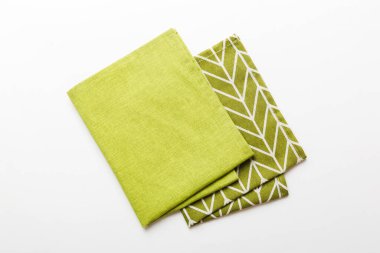 top view with green kitchen napkin isolated on table background. Folded cloth for mockup with copy space, Flat lay. Minimal style.