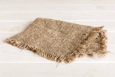 Old burlap fabric napkin, sackcloth on table background. top view with copy space.