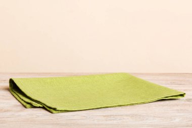 top view with green kitchen napkin isolated on table background. Folded cloth for mockup with copy space, Flat lay. Minimal style.