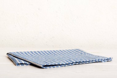 top view with blue kitchen napkin isolated on table background. Folded cloth for mockup with copy space, Flat lay. Minimal style.