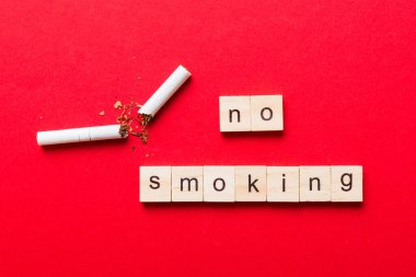 Sigara ve tahta bloklar, masa arkasında kırık sigara kum saati ile tütün günü yok, saat sağlığı konsepti. Sigarayı bırakma zamanı..