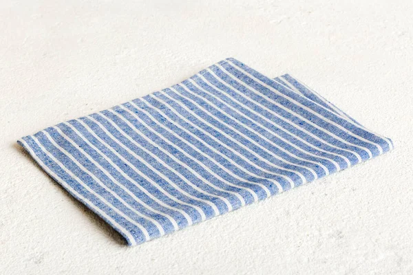 top view with blue kitchen napkin isolated on table background. Folded cloth for mockup with copy space, Flat lay. Minimal style.