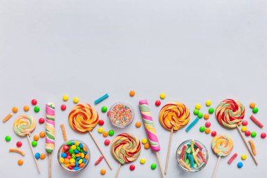 Lezzetli İştah açıcı Parti Aksesuarları Mutlu Yıllar Tatlı. Renkli arkaplanda farklı tipte şekerler, kopyalama alanı. Renkli doğum günü partisi geçmişi.