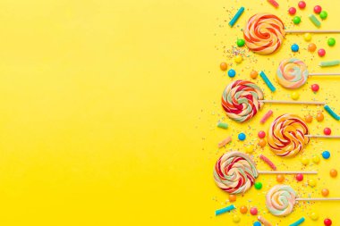 Lezzetli İştah açıcı Parti Aksesuarları Mutlu Yıllar Tatlı. Renkli arkaplanda farklı tipte şekerler, kopyalama alanı. Renkli doğum günü partisi geçmişi.