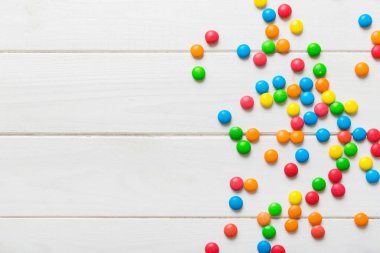 Renkli arka planda karışık renkli şeker koleksiyonu. Düz yerde, üst tarafta. Renkli çikolata kaplı şeker çerçevesi.