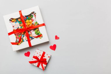 Valentine day composition: sweet candy, with gift boxes with bow and red felt hearts, photo template, background. Top View with copy space.