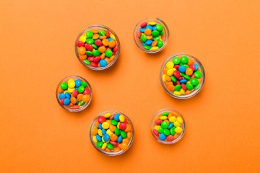 farklı renkte yuvarlak şekerler ve kavanozlar. Fotokopi alanı olan büyük çeşitlilikteki şeker ve şekerlerin üst görünümü.
